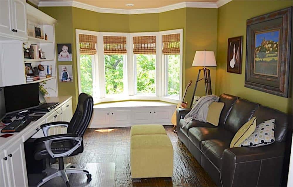 在书房里放一张皮沙发，一张白色的桌子和一个靠窗的凹边座位。