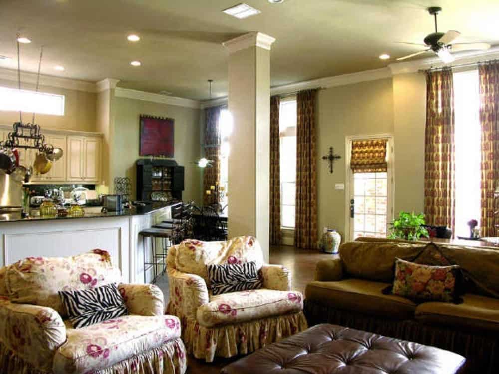 家庭活动室里有一张棕色沙发、带边扶手椅和一个皮革毡脚凳。它通向厨房和早餐角。