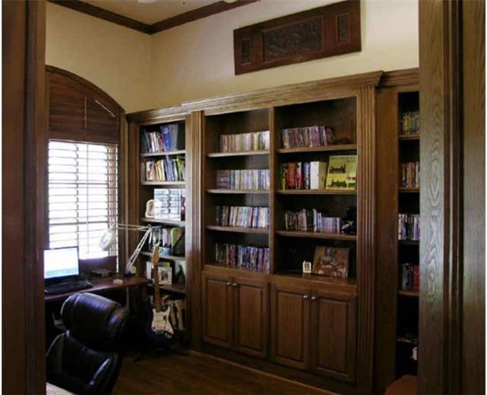 书房里有内置书架和一张木制书桌，搭配一张皮革转椅。