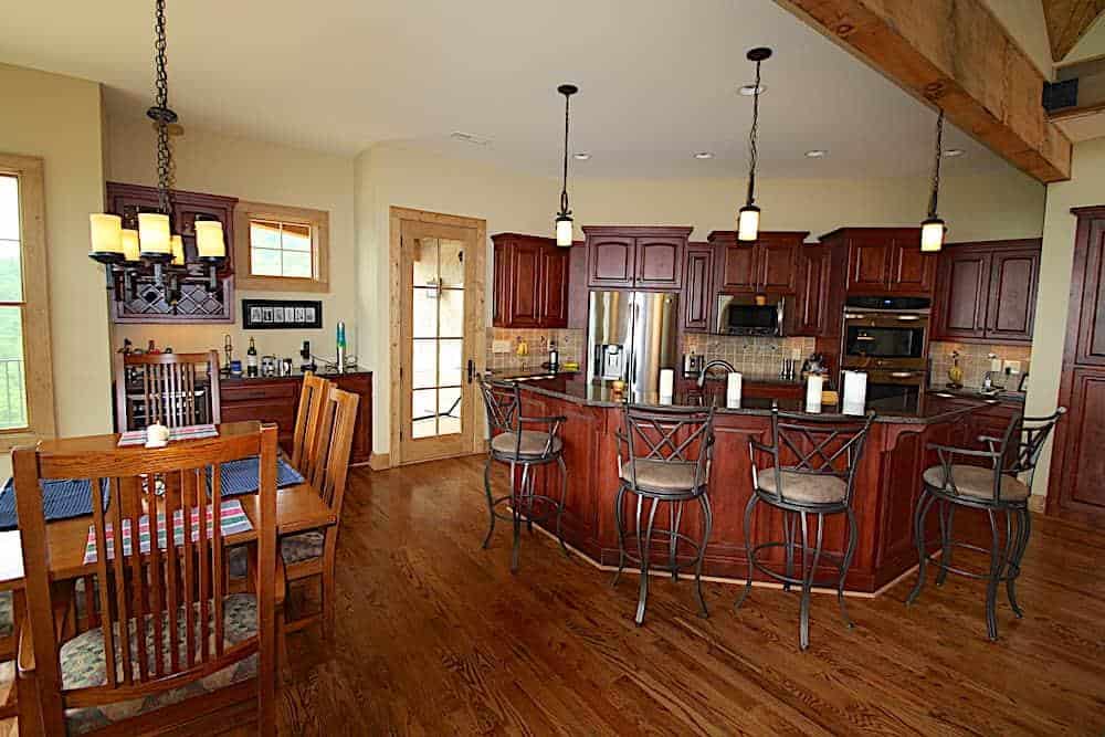 用餐厨房提供红木橱柜，一个内置的酒吧，和一个大的早餐岛搭配软垫柜台椅。