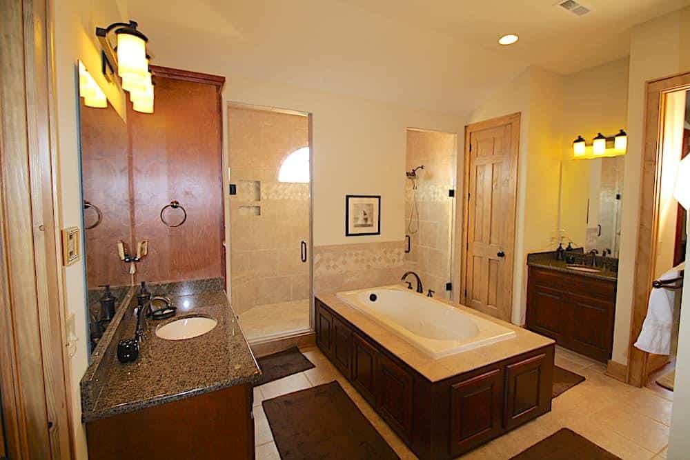主浴室配备了男女用洗手池、一个落地式浴缸和一间宽敞的步入式淋浴间，带有两扇玻璃铰链门。