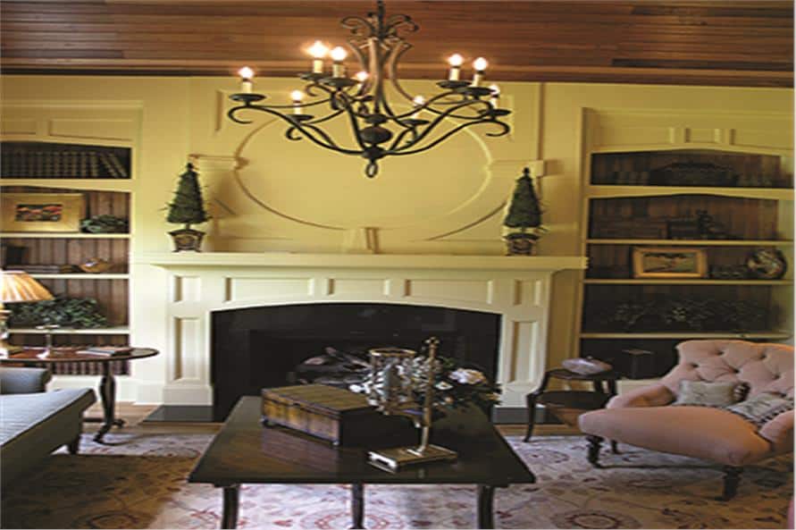 客厅里有布质扶手椅、木桌和壁炉，两侧有嵌壁式架子。