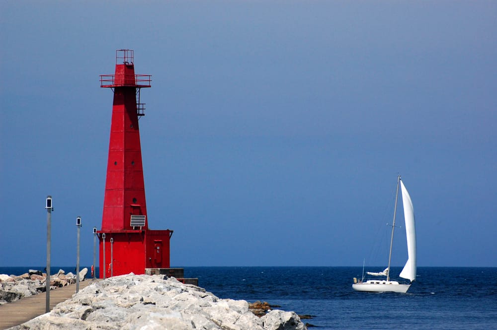 密歇根湖上的马斯基根红色灯塔和帆船。