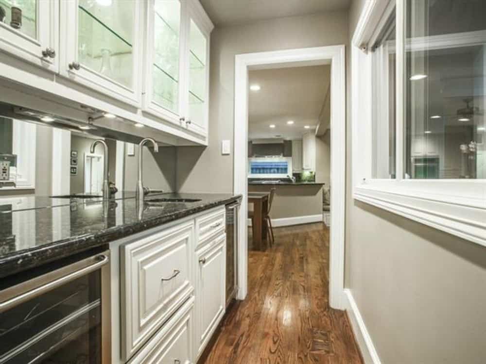 巴特勒的厨房配备座造价和白色的橱柜、水槽、冰箱饮料。