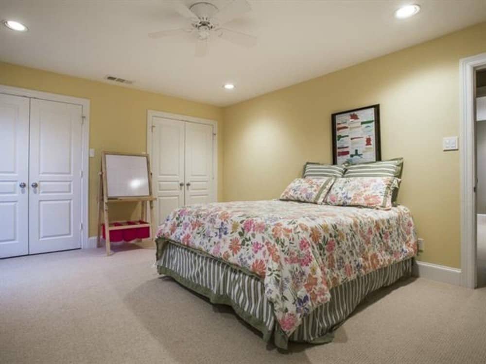 另一个卧室地毯的地板,米黄色的墙壁,和两个衣柜隐藏在白色的双扇门后面。