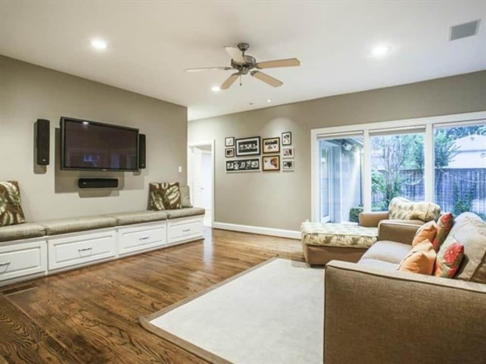家庭房间充满了米色沙发、躺椅,一个内置的长椅上顶部设有一个固定在墙上的电视。