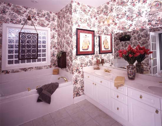 主浴室有白色的梳妆台和浴缸，在碎花壁纸的衬托下显得很突出。