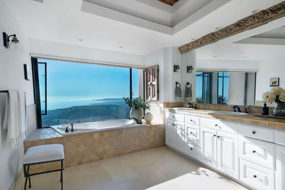 主浴室有一个双水槽虚荣和dropin浴缸与周围景观的观点。图片由Toptenrealestatedeals.com。