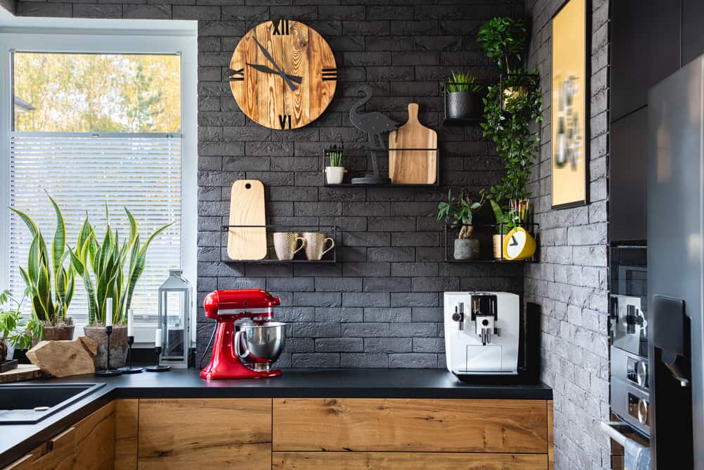 厨房有黑色砖墙和木制橱柜。