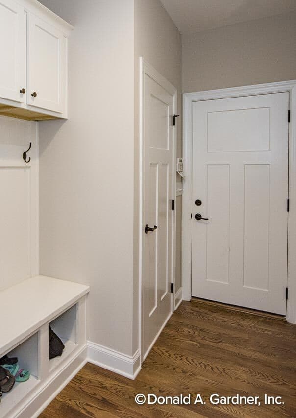 储藏室里有一个储物柜、白色橱柜和一个内置的长凳。
