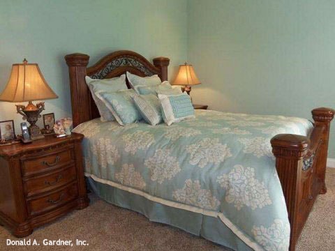 这个卧室有木制家具,地毯的地板,淡蓝色的墙壁。