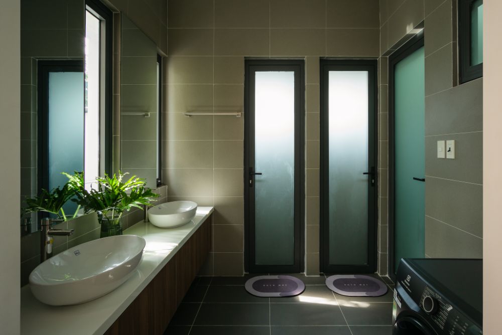 浴室有两个桌面椭圆形白色水槽，全长镜子和两扇门通往淋浴房。