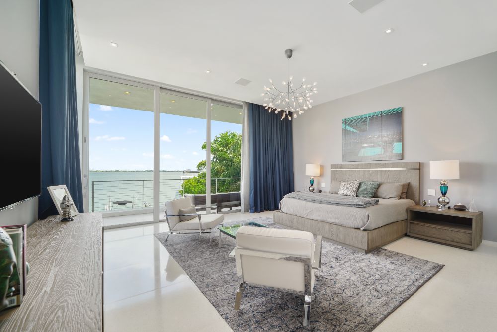 现代白色粉刷的卧室与比斯坎湾的美景。