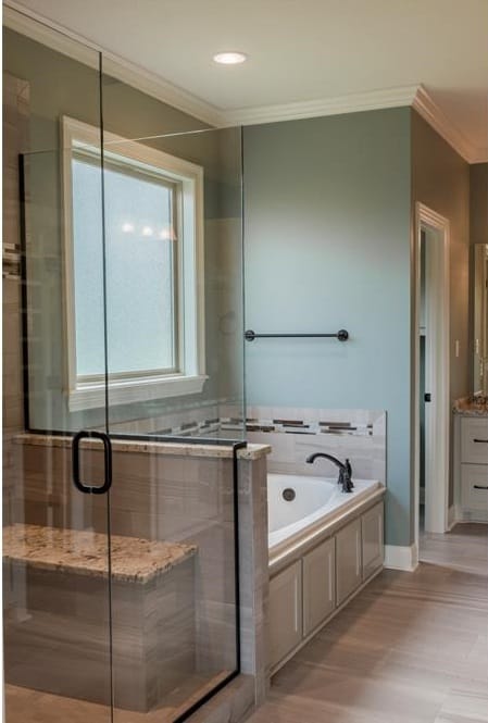 主浴室包括一间卫生间、一间步入式淋浴间和一间带观景窗的浴缸。