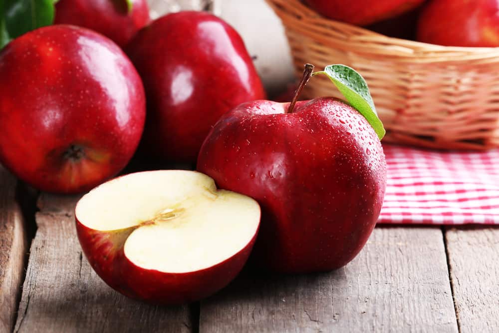 新鲜的苹果水果放在木板桌上。