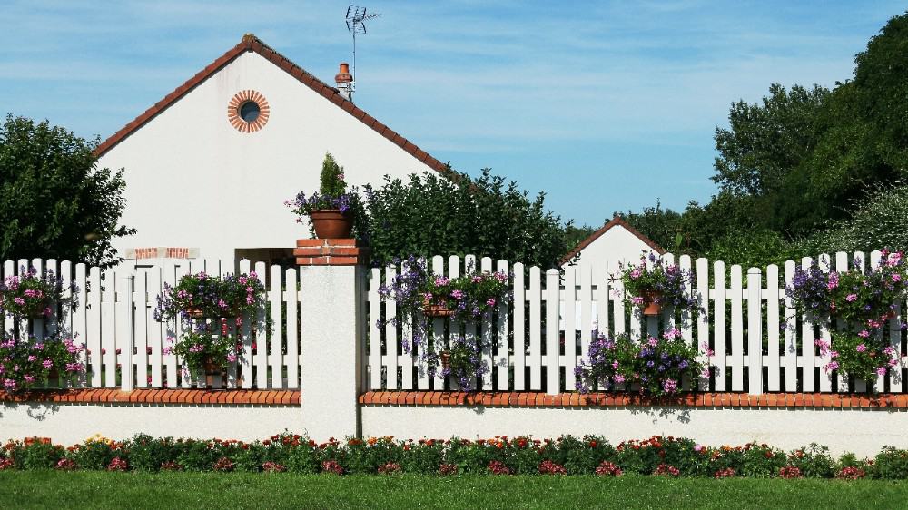 住宅与白色尖桩篱笆装饰的鲜花。