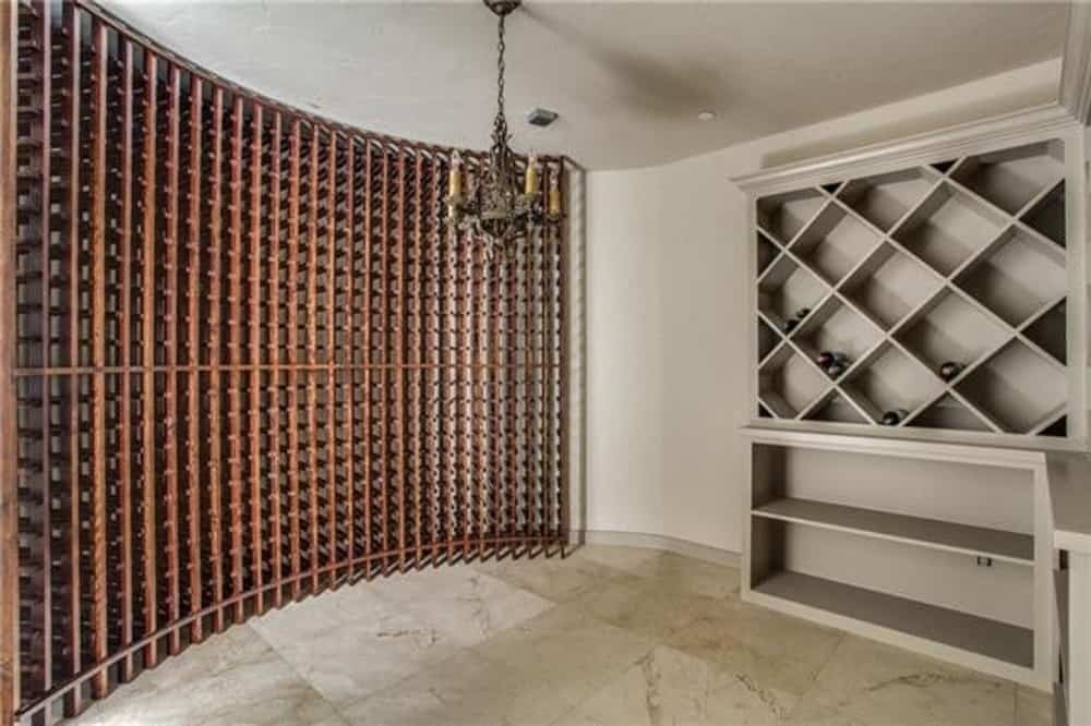 葡萄酒室与大理石瓷砖地板，地板到天花板的小隔间，和一个纵横交错的货架下面。