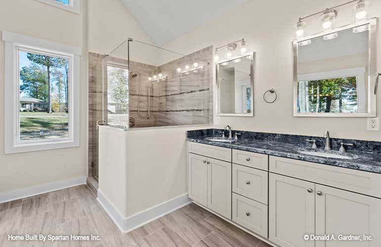 主浴室带步入式淋浴和双水槽梳妆台，配有镜框镜子和玻璃烛台。