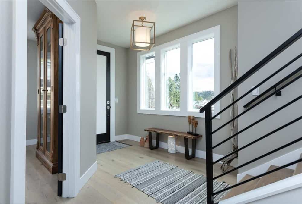 门厅里有一条木凳，一条条纹地毯，还有一条通往楼上卧室的楼梯。