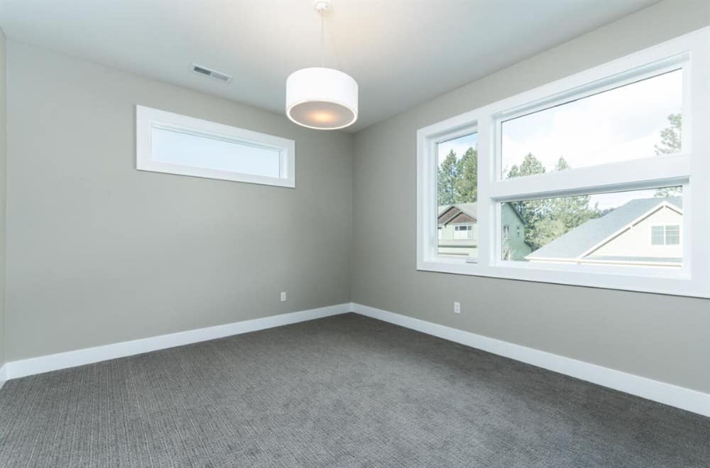 这间卧室有灰色的墙壁、地毯地板和天窗，可以引入自然光。