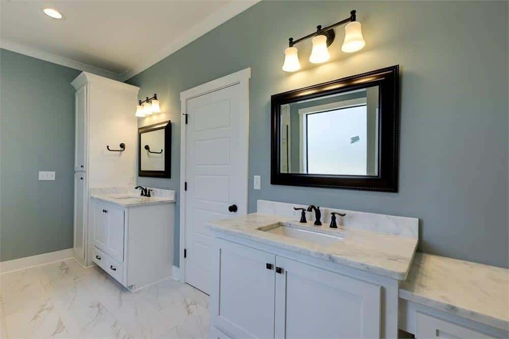 主浴室包括男女洗手池梳妆台，上面有黑框镜子和温暖的烛台。