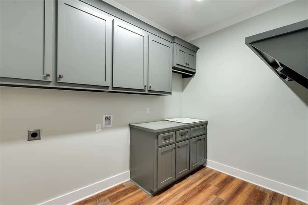 洗衣房，硬木地板，灰色橱柜，还有一个多功能水槽。