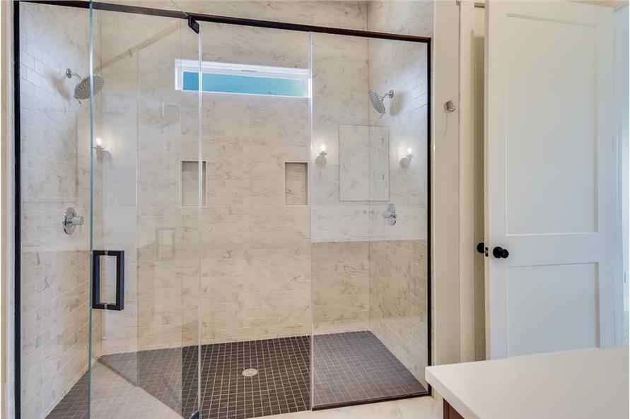 仔细看看步入式淋浴间，有两个淋浴头，嵌式架子，天窗和玻璃铰链门。