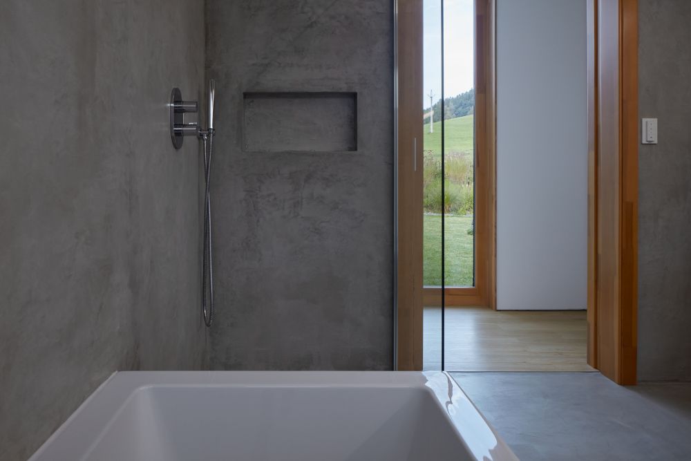淋浴房带有矩形凹室式浴缸和钢制淋浴。