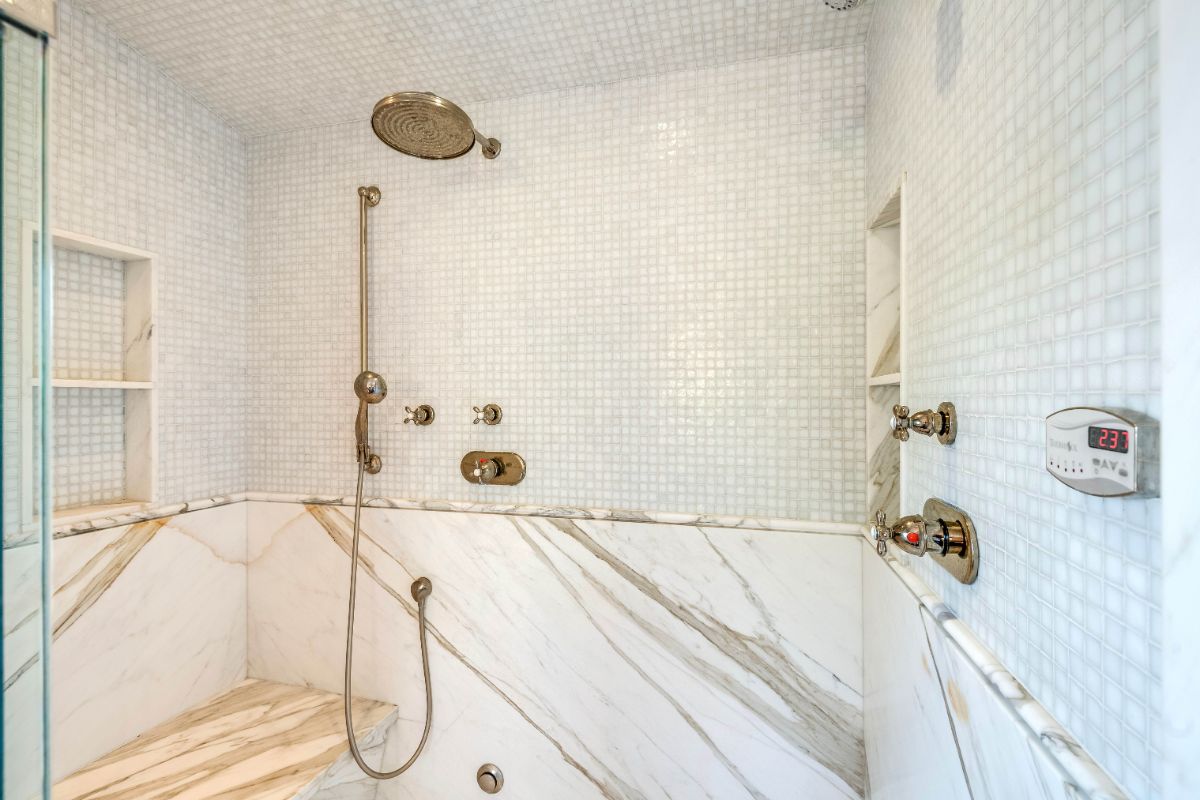 浴室里有大理石蒸汽淋浴间，带玻璃门。图片来自Toptenrealestatedeals.com