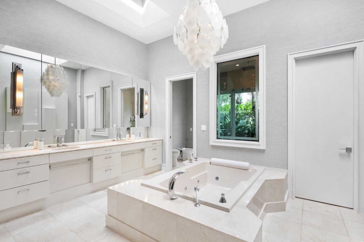 现代主浴室，中心设有内置浴缸，全长镜子和现代照明。