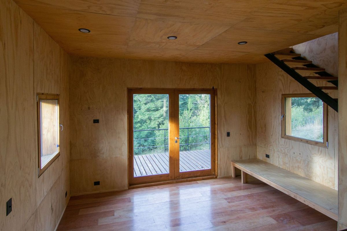 生活空间完全覆盖着被单的松木胶合板,玻璃门窗。