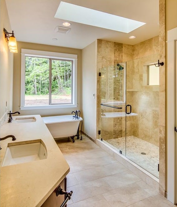 主浴室设有一个双洗手池梳妆台、一个宽敞的步入式淋浴间，以及一个位于滑动窗下的爪形浴缸。