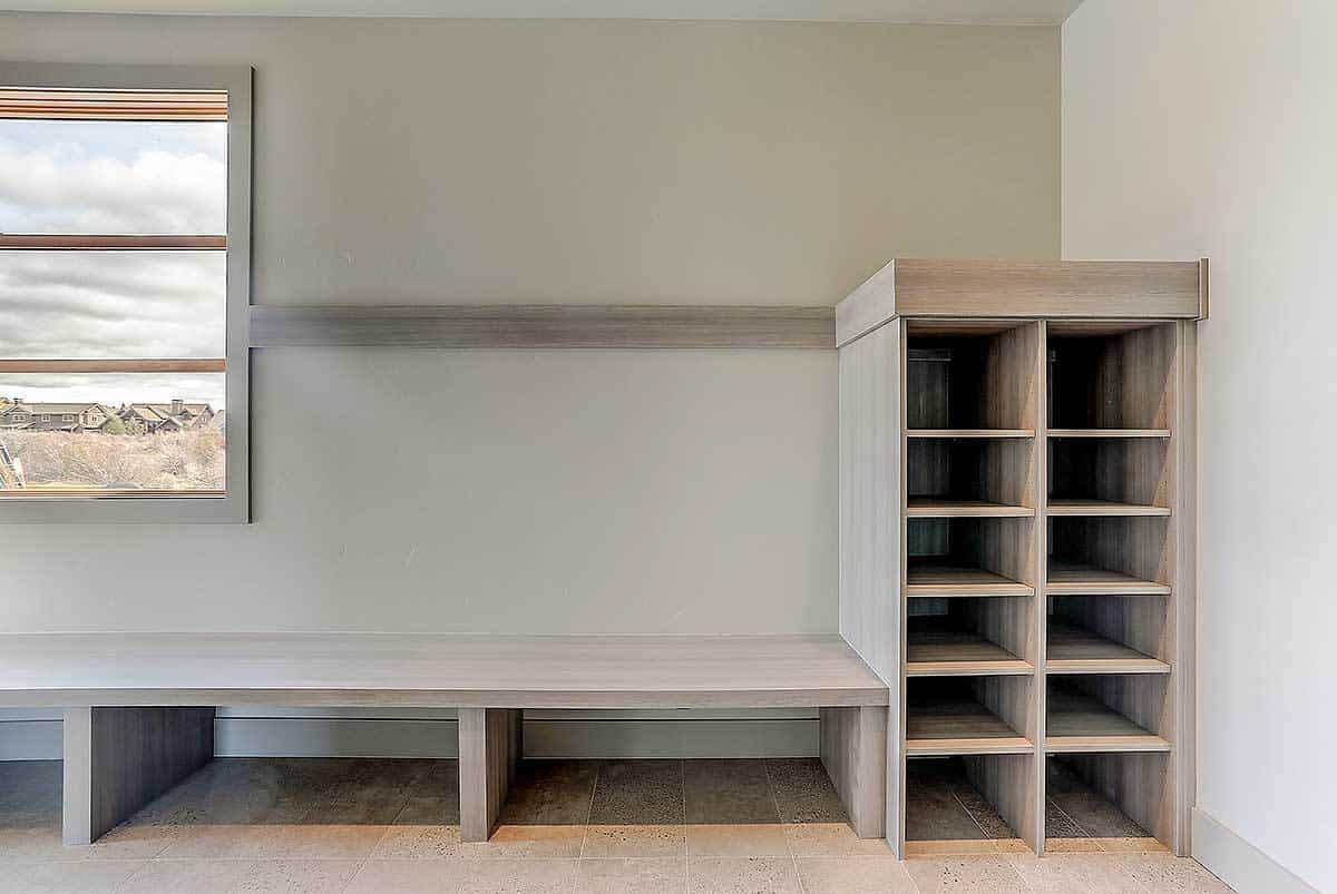有嵌壁式架子的储藏室和一条固定在灰色墙壁上的细长长凳。