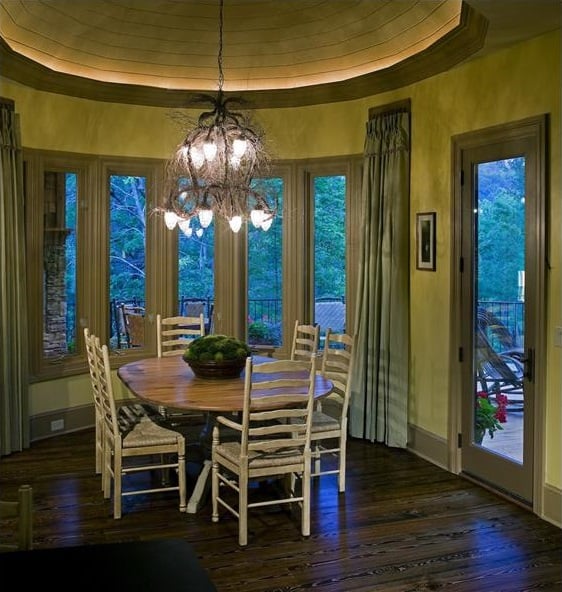 有一扇弓窗的早餐角落，一套圆形餐厅，一盏质朴的枝形吊灯悬挂在圆顶天花板上。