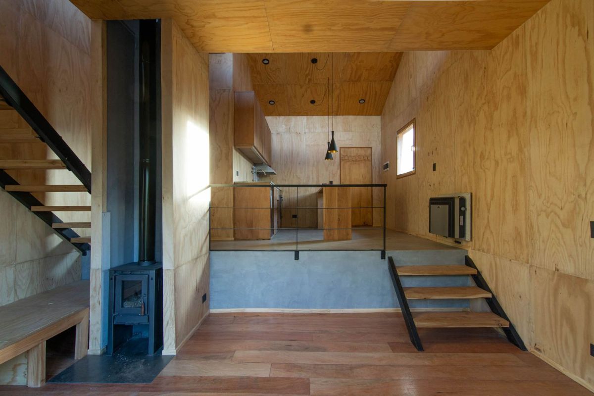 生活空间的三个步骤楼梯导致厨房都覆盖着松木胶合板的床单。
