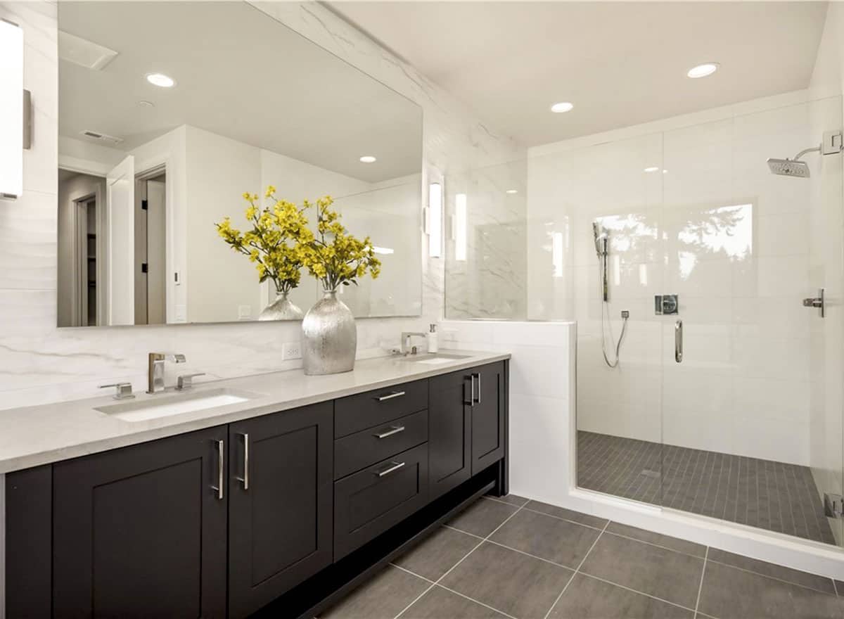 主浴室设有一间步入式淋浴间和一个双洗手池梳妆台，并配有一面无框镜子。