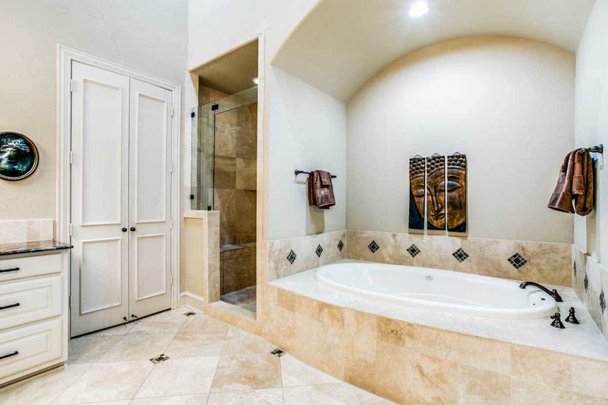 主浴室壁龛浴缸,淋浴区,一个大壁橱隐藏在白色的双扇门。