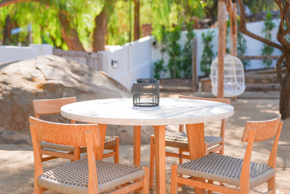 一个四座圆形木桌和椅子提供户外用餐。