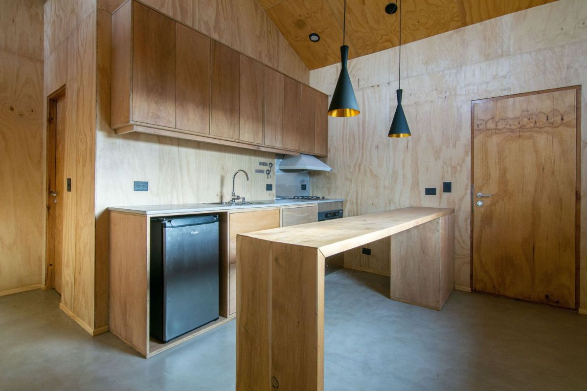 厨房区域所有覆盖着松木胶合板的完整表包括橱柜和表。