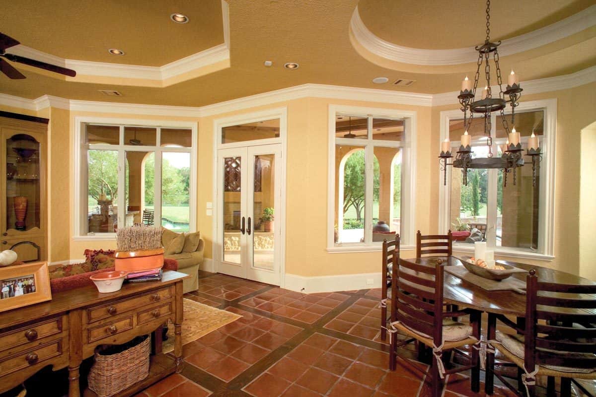 在托盘天花板下，早餐角，厨房和家庭娱乐室的开放式布局视图。