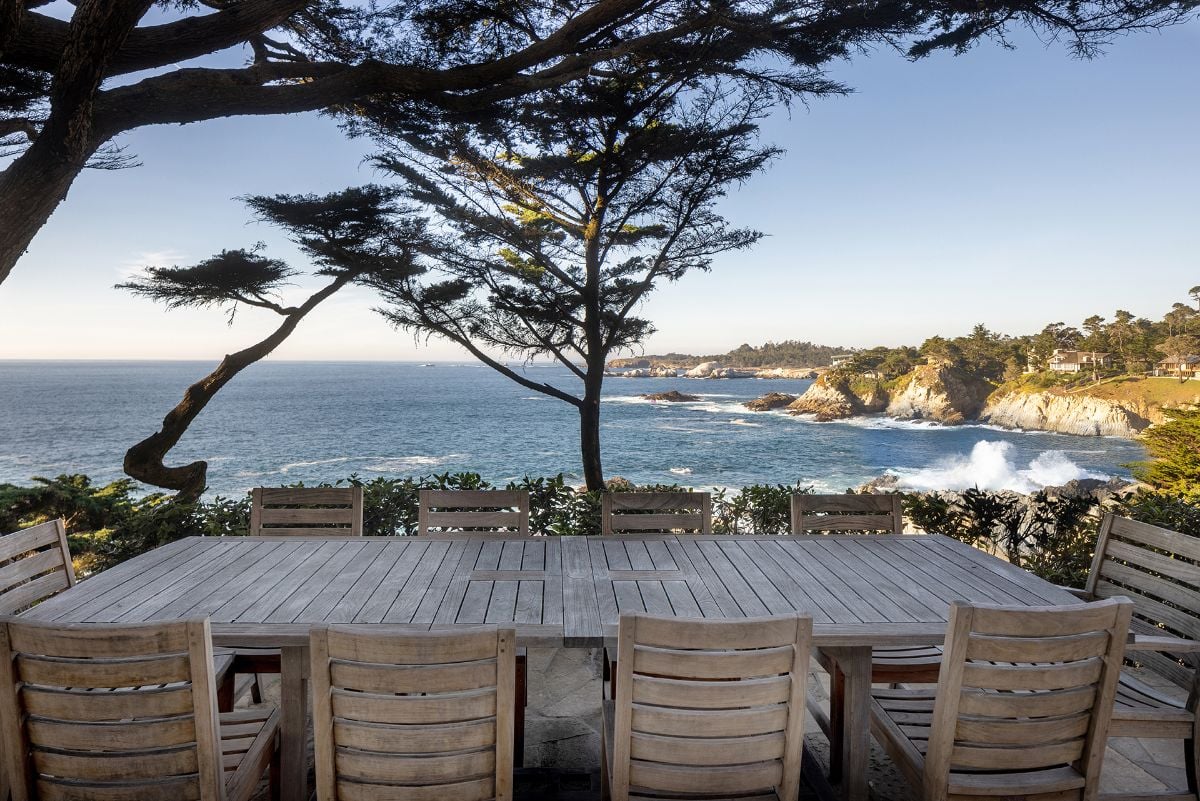 享受豪华的户外用餐体验，在树荫下的十座木制矩形桌子和海岸线的壮丽景色。图片来自Toptenrealestatedeals.com