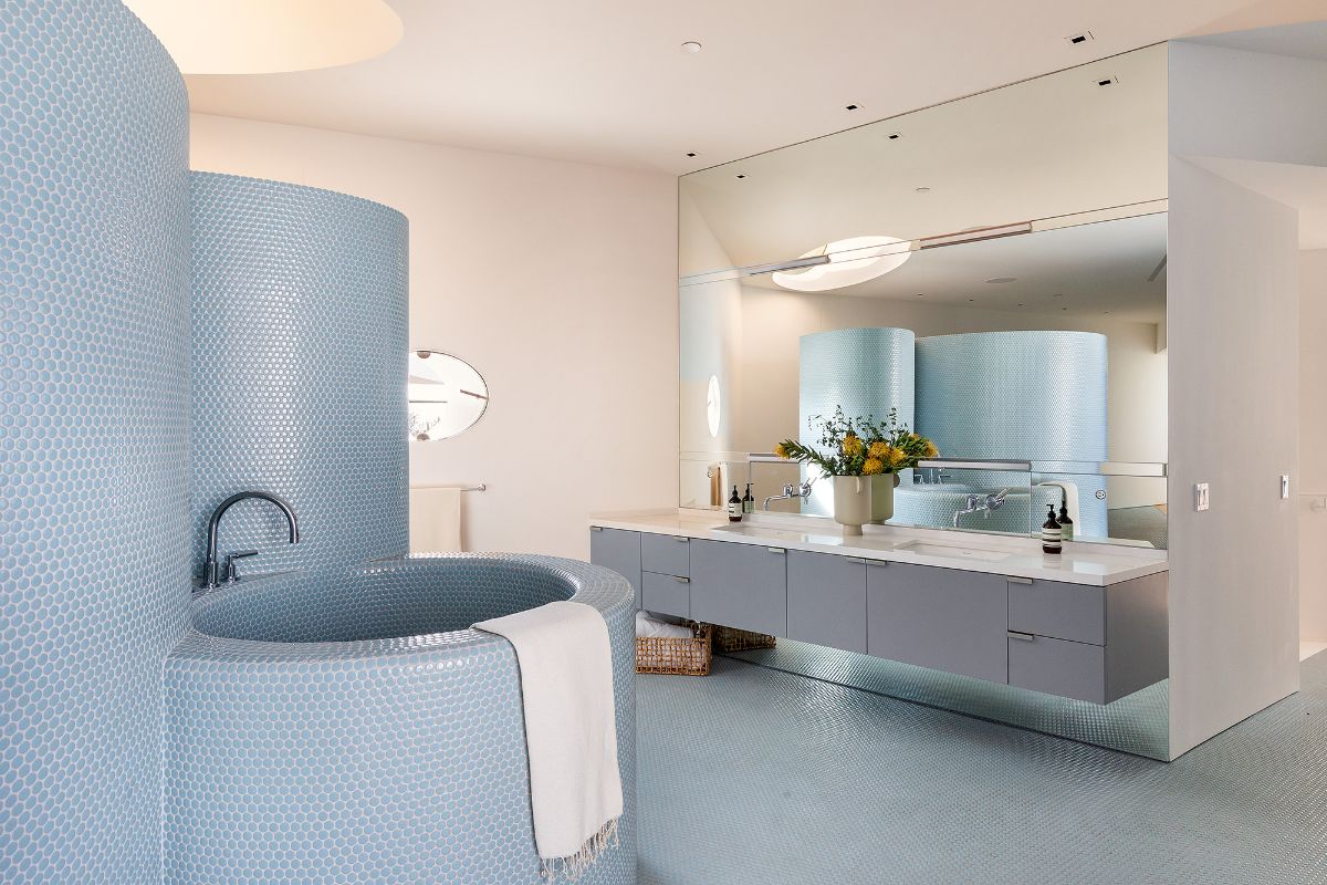 一间带长镜和定制浴缸的廉价瓷砖浴室。