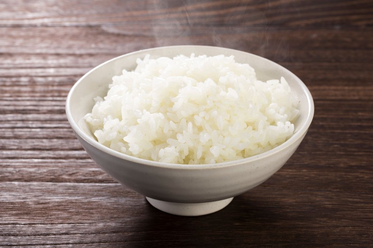 木桌上摆着白碗里的白米饭。