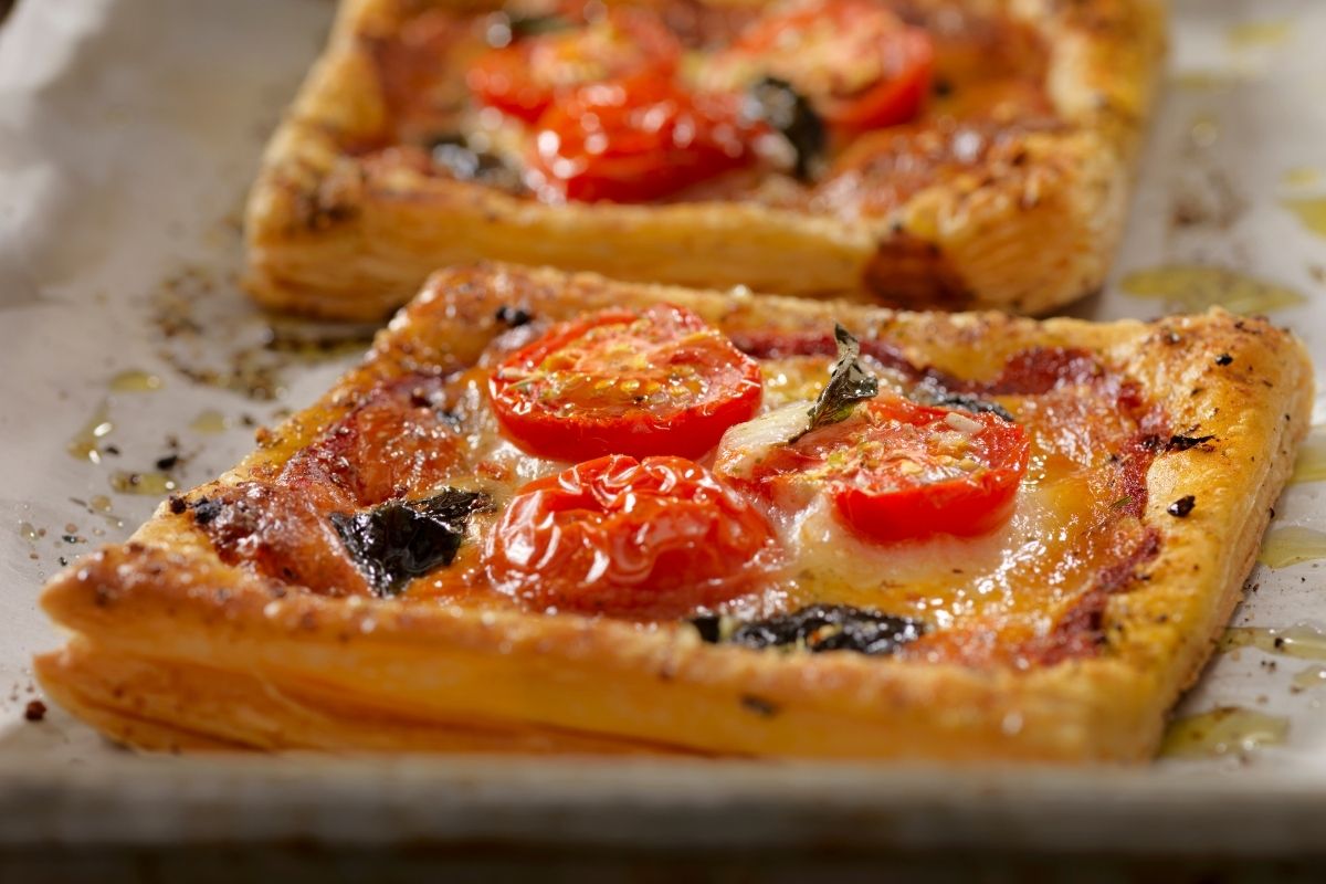 美味的西红柿酥皮披萨的特写照片。