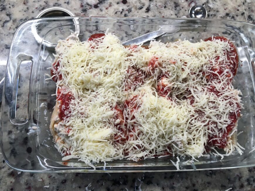 超载Mozarella乳酪放置在充塞壳顶部用蘑菇和意大利香肠。