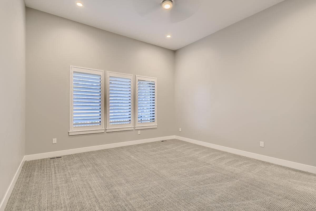 这间卧室以其地毯地板和配套的灰色墙壁为特色。