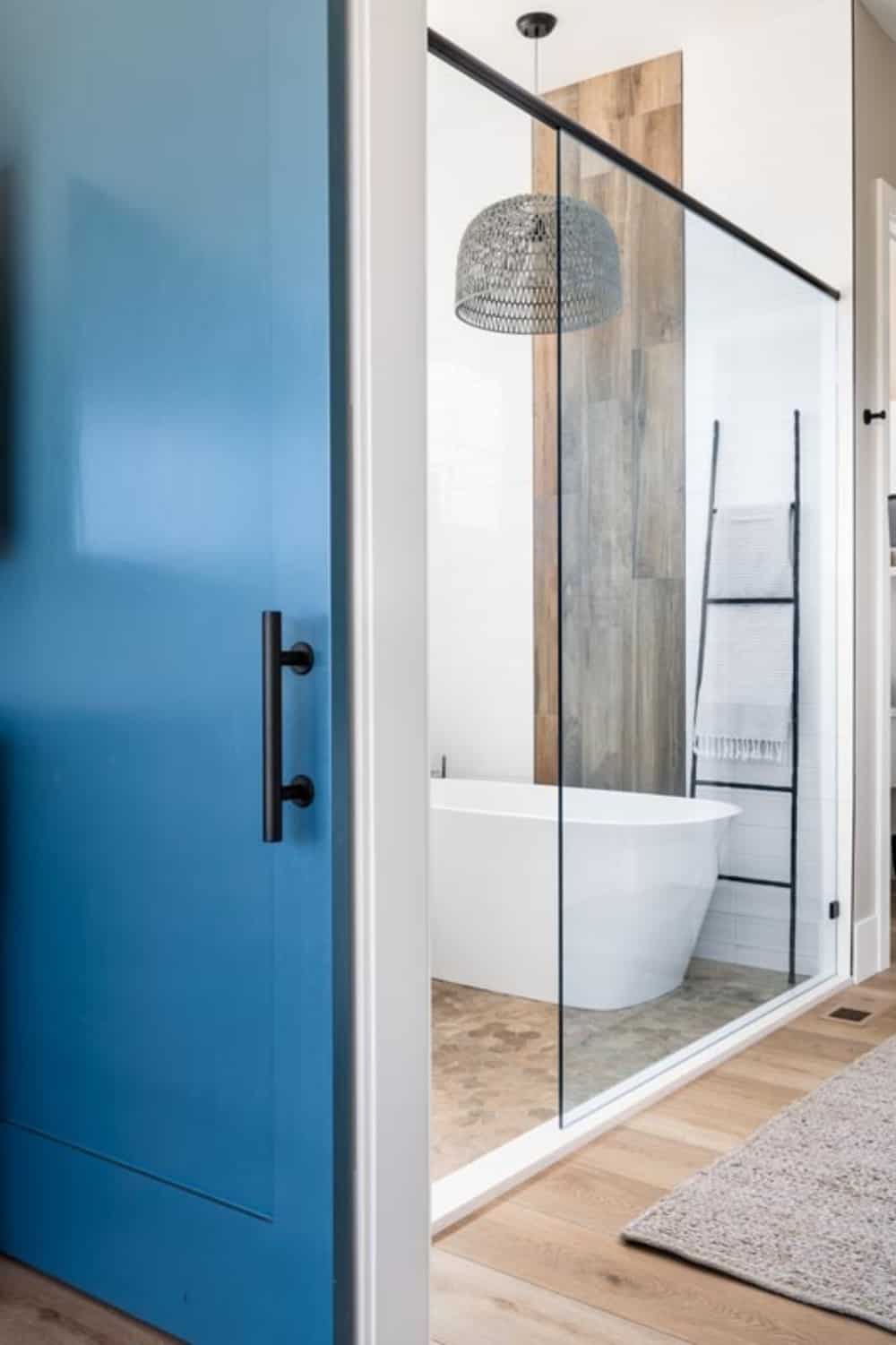 主浴室带步入式淋浴，配备独立浴缸和毛巾梯架。