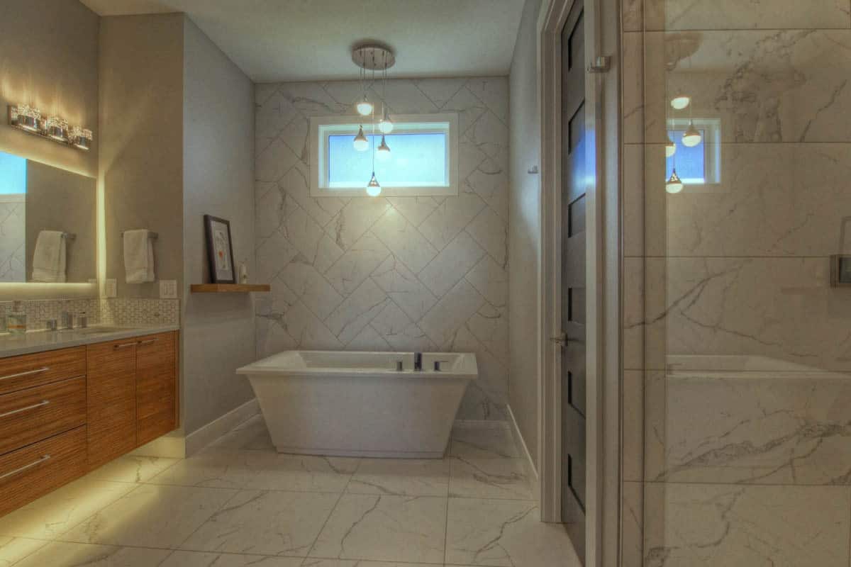 主浴室里铺着大理石瓷砖地板，有一个木制梳妆台，还有一个独立的浴缸，上面挂着层层叠叠的垂饰。