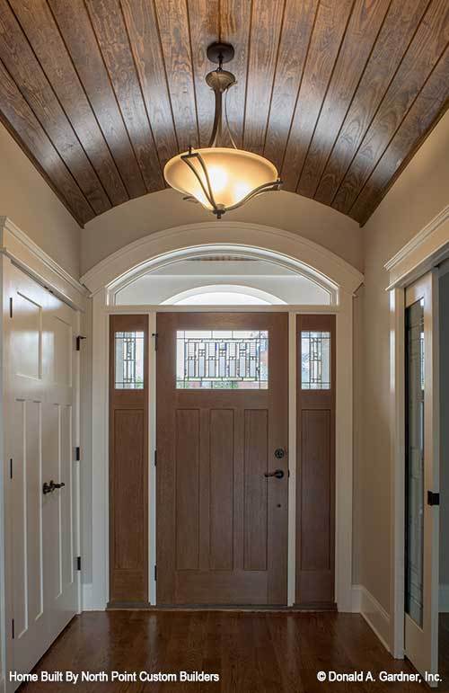 门厅有一扇木门和一个包有天然木板的桶形穹顶天花板。