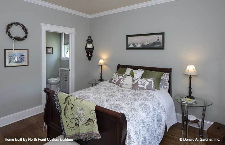 这间卧室里有一张舒适的木床，灰色的墙壁上点缀着白色的装饰。